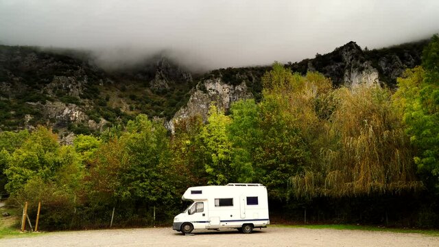 Camper rv camping on nature in rocky mountains on rainy cloudy day. Agurain, Basque Country, Spain. Adventure with motor home.