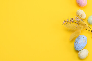 Flat lay Easter composition with a eggs, gypsophila and lagurus on a yellow background. copy space