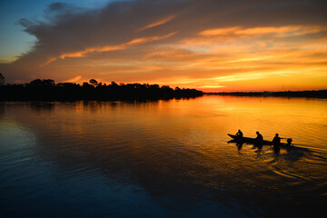 A small motorized canoe on the Guaporé - Itenez river during sunset, Ricardo Franco village, Vale...