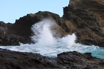 Waves crash onto the rocks on the island of Oahu, Hawaii