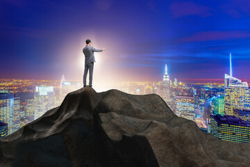 Businessman at the top of mountain in career concept