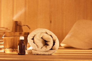 Obraz na płótnie Canvas Essential oil with a towel in a roll in a bath or sauna.