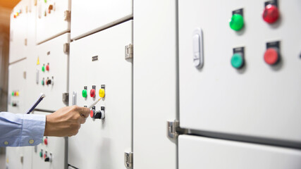 Electricity and electrical maintenance service, Engineer checking air handling unit AHU starter button control panel and hvac system of air conditioner load center cabinet for maintenance.