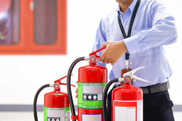 Fire extinguisher, Firefighter checking handle of fire extinguisher tank in the building concepts...