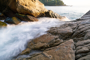 Beautiful long exposure seascape with sea wave forms a dense white foam on the rocks seashore cliff Seascape background