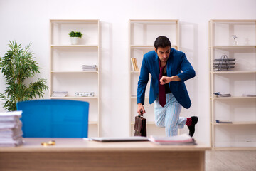 Young male employee in oversleeping concept