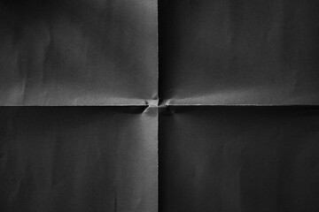 Black paper folded in four fraction background