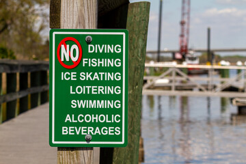 An extensive list of actions forbidden on the dock area are shown. The sign says no to diving,...