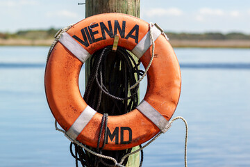 A lifebuoy attached to a dock post on the pier in Vienna, Maryland. This is a historic colonial era...