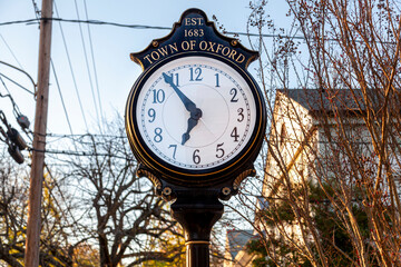 Close up isolated image of a stand alone vintage clock in the town center of Oxford Maryland. It...