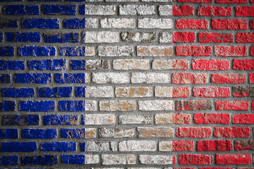 National flag of France depicting in paint colors on an old brick wall. Flag  banner on brick wall background.