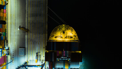 Aerial top view of Containers cargo ship at night. Business logistic transportation sea freight, Cargo ship, Cargo container in deep sea port at industrial estate for import export around in the world