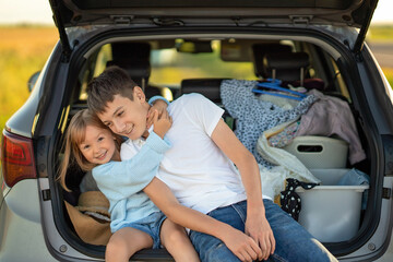 family traveling in car, Brother and sister having fun. Kids being kids. brother and sister sitting in the trunk and fooling around,  car trip concept