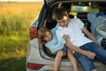 family traveling in car, Brother and sister having fun. Kids being kids. brother and sister sitting in the trunk and fooling around,  car trip concept