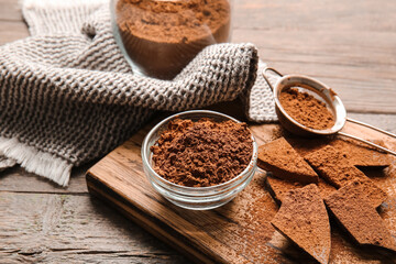 Bowl and sieve with cocoa powder on wooden background