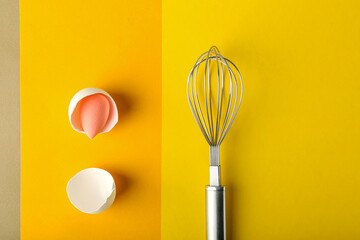 Creative composition with makeup sponge and whisk on color background