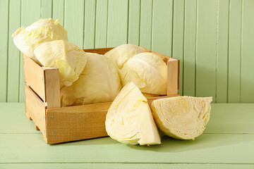 Fresh cut cabbages on color wooden background