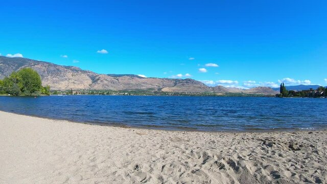 View of the Osoyoos Lake and a beach during a sunny summer day. Osoyoos is a town in the Okanagan Valley region of British Columbia, Canada.