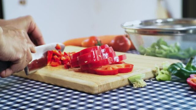 Close up housewife hand slice Sweet pepper  or bell papper by knife for cooking in Kitchen