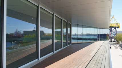 Reflections in an angle of the harbourfront water against shipyard tower and promenade below from the balcony