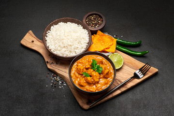 Plate of Traditional Chicken Curry, rice and spices on dark concrete background