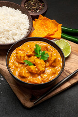 Plate of Traditional Chicken Curry, rice and spices on dark concrete background