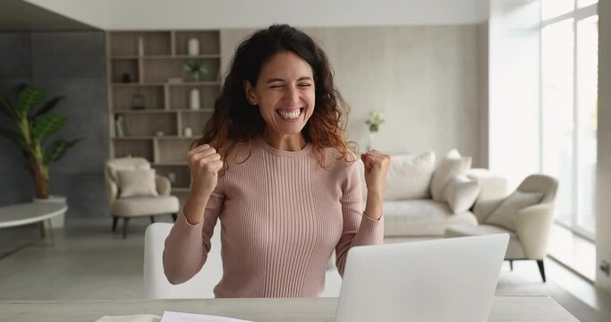 Young woman sit at desk in cozy living room read e-mail on laptop celebrate great news unbelievable success in business, career advance, sales growth. Candid emotions, moment of luck, victory concept