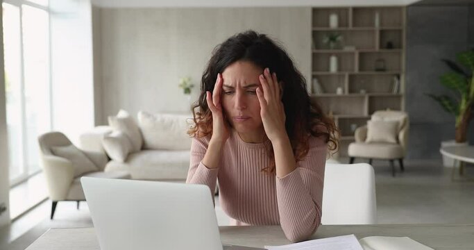 Woman sit at desk use laptop read unpleasant e-mail feels stressed. Upset female experience problems with computer, system failure, backup issue, lost important information, need device repair concept