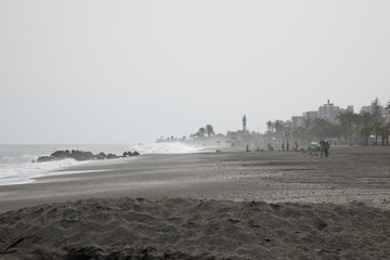 On a windy day at the beach with large waves from the ocean 