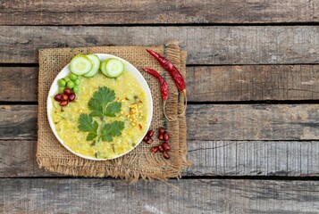 Khichdi or Cracked Wheat Khichuri in a Plate with Coriander Leaf, Green Pea, Cucumber Slices and...