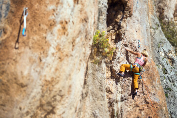 A girl climbs a rock.