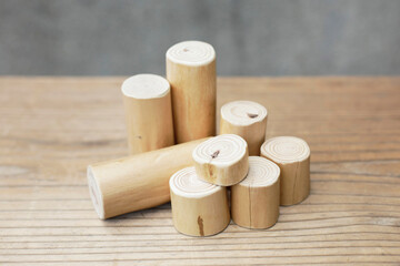 Thin and short barkless wooden log blocks on wooden table. Barkless cedar log set closely together sat on wooden background. 