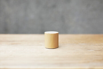Thin and short barkless wooden log block on wooden table. Barkless cedar log on wooden background. 