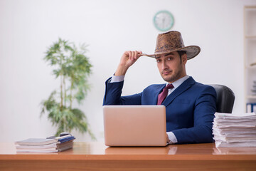 Young cowboy businessman working at workplace