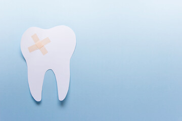 One large paper tooth with patch on blue background