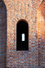 Shaped window in ancient brick wall. A fragment of old Smolensk Kremlin fortress.