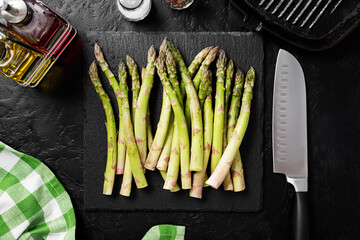 Fresh asparagus for salad or smoothies, healthy food for vegans and raw foodists. Black background, top view