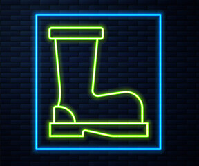 Glowing neon line Fire boots icon isolated on brick wall background. Vector