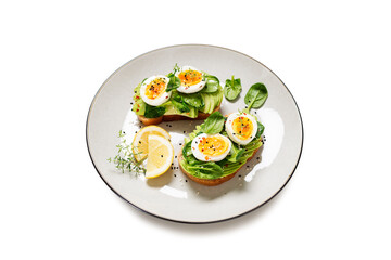 Healthy toast with sliced avocado, boiled eggs, spices and fresh spinach. Delicious breakfast or snack, isolated on white background
