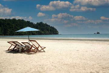 A beach chairs and umbrellas located on the  beach on an island in Thailand.