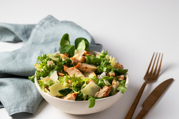 Healthy  Cesar salad with different  lettuce, chicken, parmesan cheese and croutons on white...