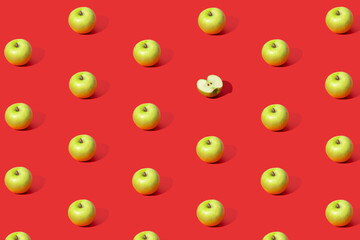 Colorful fruit pattern of fresh green apples on red background. From top view.
