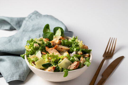 Healthy  Cesar Salad With Different  Lettuce, Chicken, Parmesan Cheese And Croutons On White Background. Copy Space