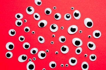 A bunch of toy eyes on an red background