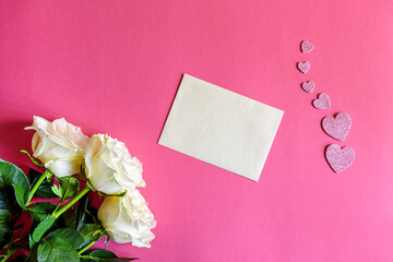 Postcard with three white roses on a pink background with hearts. Greeting card with the concept of flowers. Holiday greeting card. Top view, flat lying.