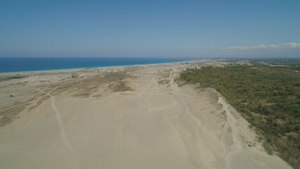 Aerial view of beautiful lonely beach and Paoay sand dune. Philippines, Luzon. Sand dunes near to the sea with sky. Ilocos Norte.