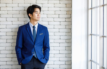 Portrait closeup shot of Asian young intelligence college teen student wears blue formal suit...