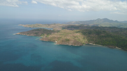 Aerial view of seashore with beach, lagoons and coral reefs. Philippines, Luzon. Ocean coastline with turquoise water. Tropical landscape in Asia.