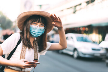 Young adult tourist asian traveller women wear protective face mask and eyeglasses  for virus...