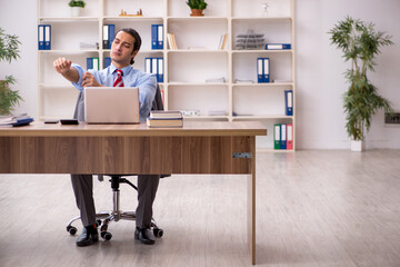 Young male employee sitting at workplace